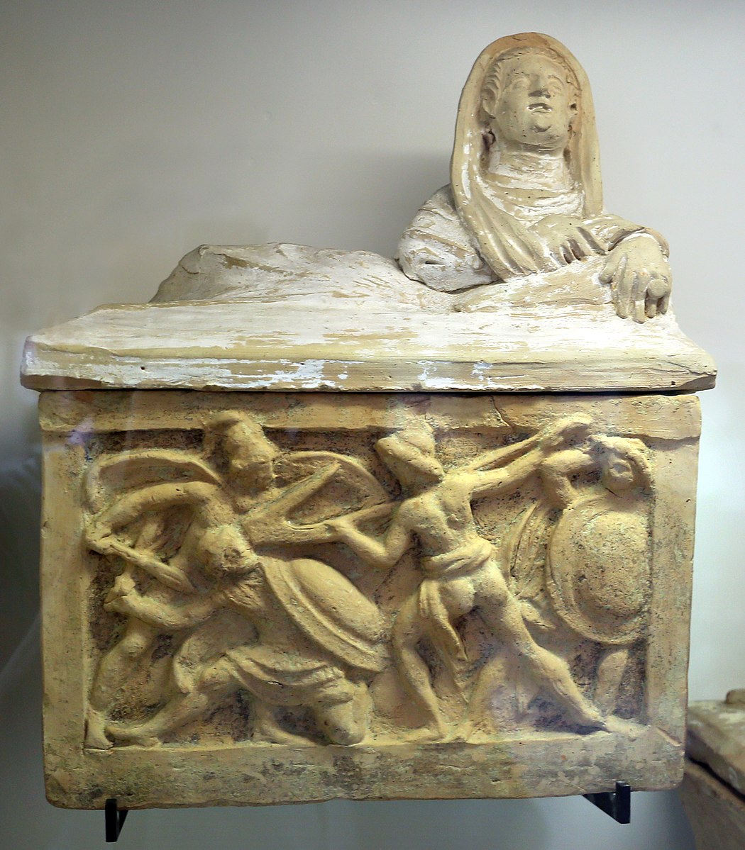 combat Volterra,_urna_cineraria_(guerriero_con_aratro)_Museo archeologico nazionale (Parma)